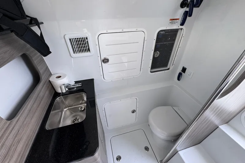  Yacht Photos Pics 2026 Invincible 43 Open Fisherman boat bathroom with sink, toilet, and storage compartments.