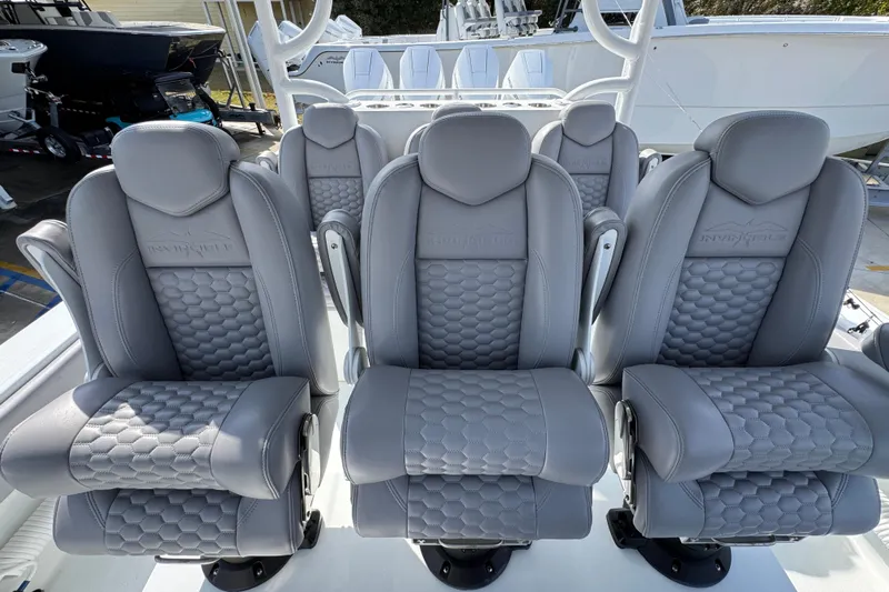  Yacht Photos Pics Luxurious seating on 2026 Invincible 43 Open Fisherman boat, featuring sleek gray upholstery.