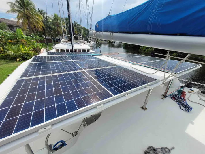 Stella Maris Yacht Photos Pics Solar panels on a 2016 Custom 50 Len Jenkins boat, docked near tropical foliage.