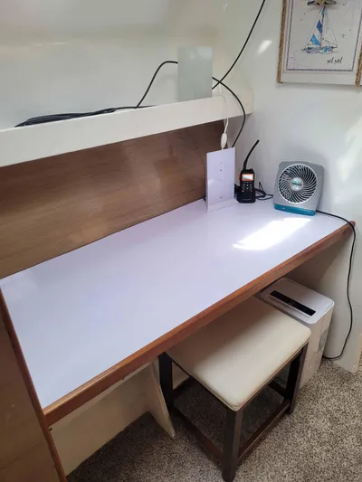 Stella Maris Yacht Photos Pics A minimalist desk setup with a fan, radio, and framed sailboat picture.