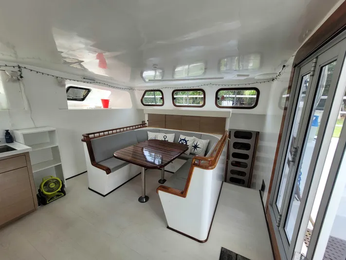Stella Maris Yacht Photos Pics Interior of 2016 Custom 50 Len Jenkins boat with seating area and table.
