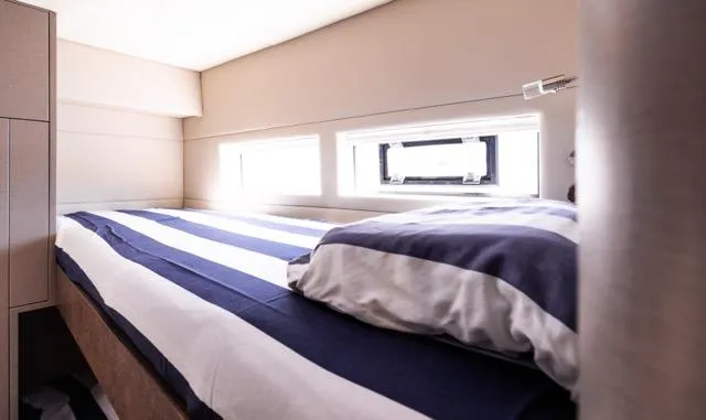  Yacht Photos Pics Cozy bedroom in 2024 Eyecat 55 Autumn yacht with striped bedding and natural light.