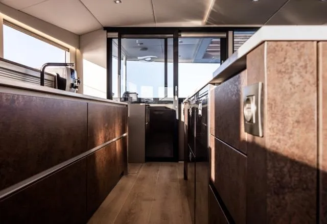  Yacht Photos Pics Modern kitchen interior on 2024 Eyecat 55 Autumn yacht, featuring sleek cabinetry and wood flooring.