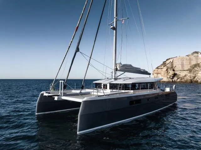  Yacht Photos Pics Luxurious 2024 Eyecat 55 Autumn catamaran sailing near rocky coastline.