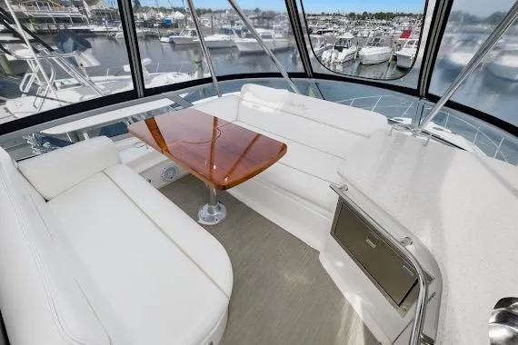  Yacht Photos Pics Luxurious interior of 2008 Sea Ray 47 Sedan Bridge yacht with white seating and wooden table.
