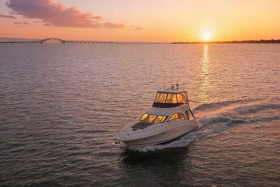  Yacht Photos Pics 2008 Sea Ray 47 Sedan Bridge yacht cruising at sunset on open water.