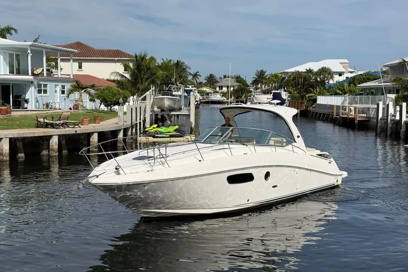  Yacht Photos Pics 2012 Sea Ray 370 Sundancer cruising in a scenic canal with waterfront homes.