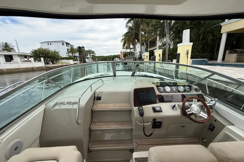  Yacht Photos Pics 2012 Sea Ray 370 Sundancer helm with modern controls, docked near waterfront homes.