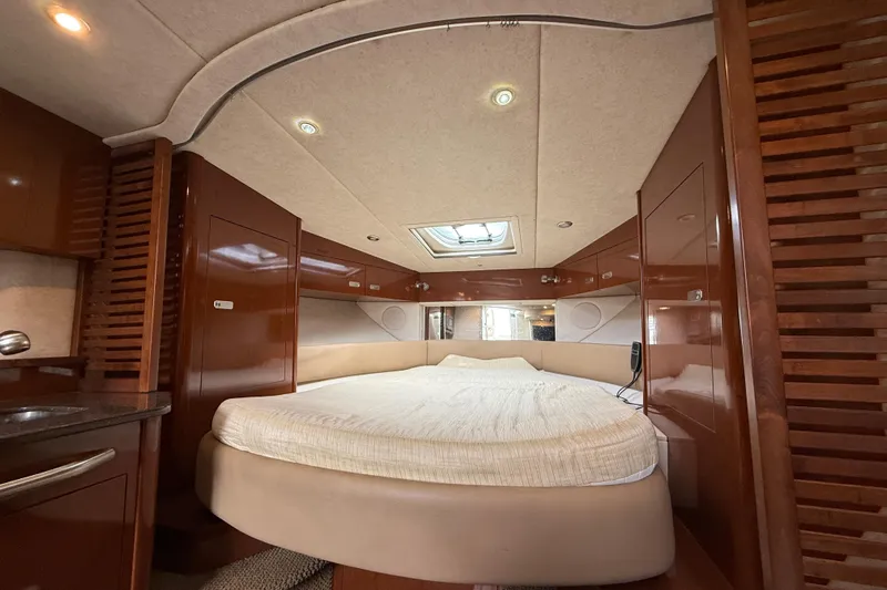  Yacht Photos Pics Luxurious interior cabin of 2012 Sea Ray 370 Sundancer yacht with cozy bed and wood finish.