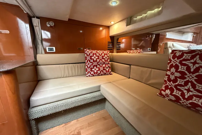  Yacht Photos Pics Luxurious interior of 2012 Sea Ray 370 Sundancer with beige seating and red floral pillows.