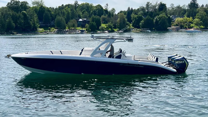  Yacht Photos Pics 2022 Midnight Express 37 Open boat on a serene lake with lush green shoreline.