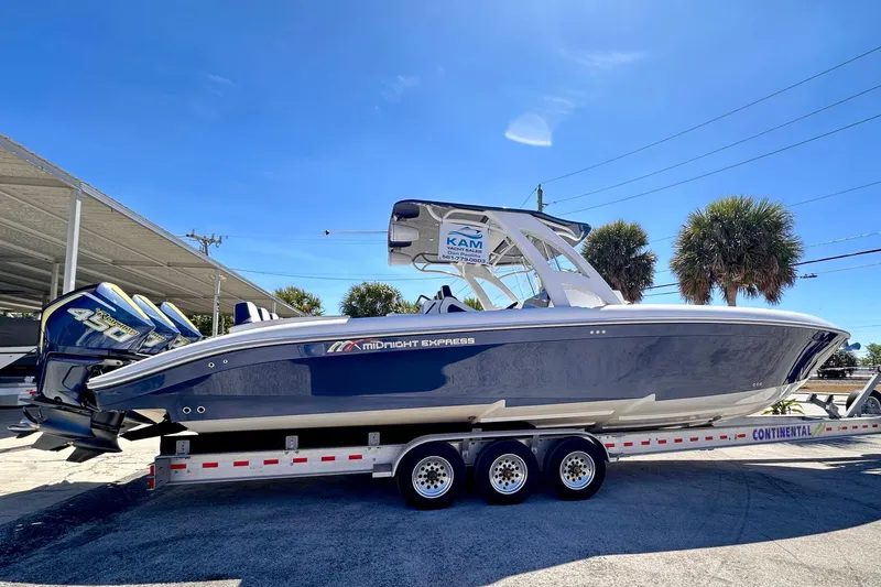  Yacht Photos Pics 2022 Midnight Express 37 Open boat on trailer under clear blue sky.