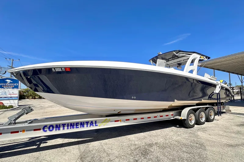  Yacht Photos Pics 2022 Midnight Express 37 Open boat on a Continental trailer under clear blue sky.