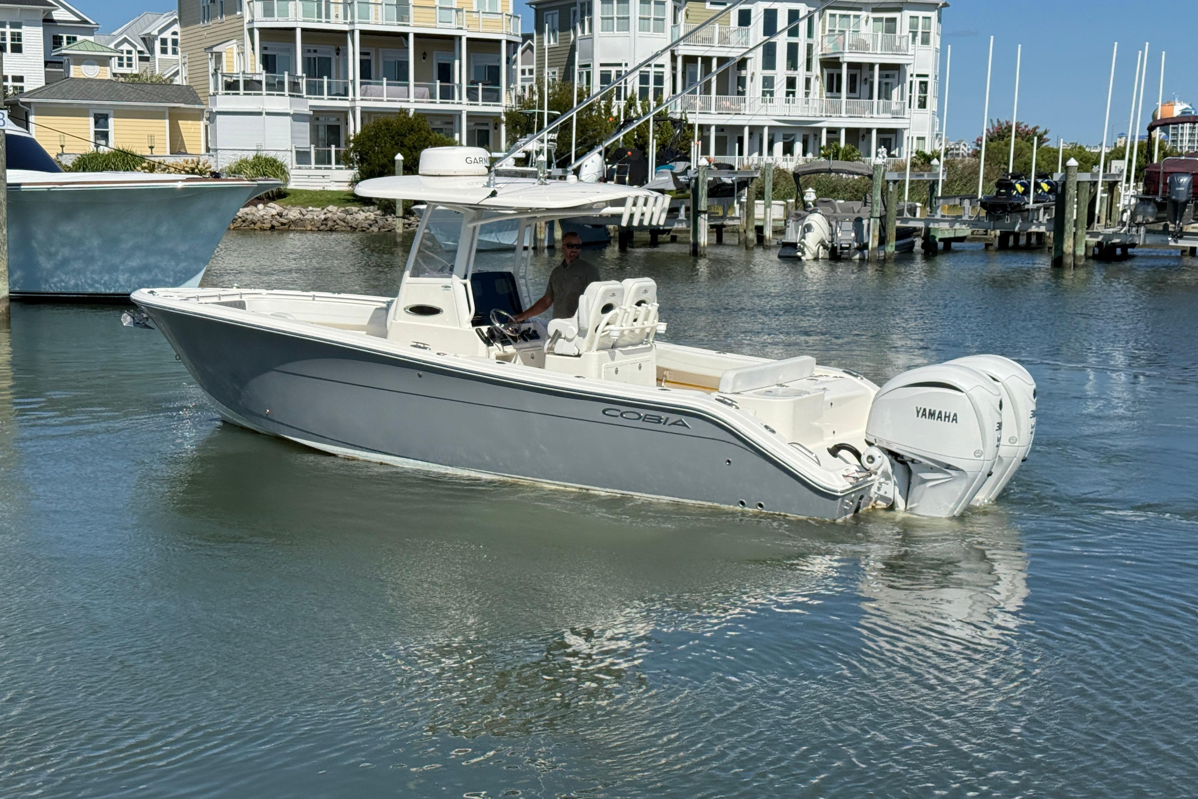 2023 Cobia 280 Center Console boat with Yamaha engine in a marina setting.