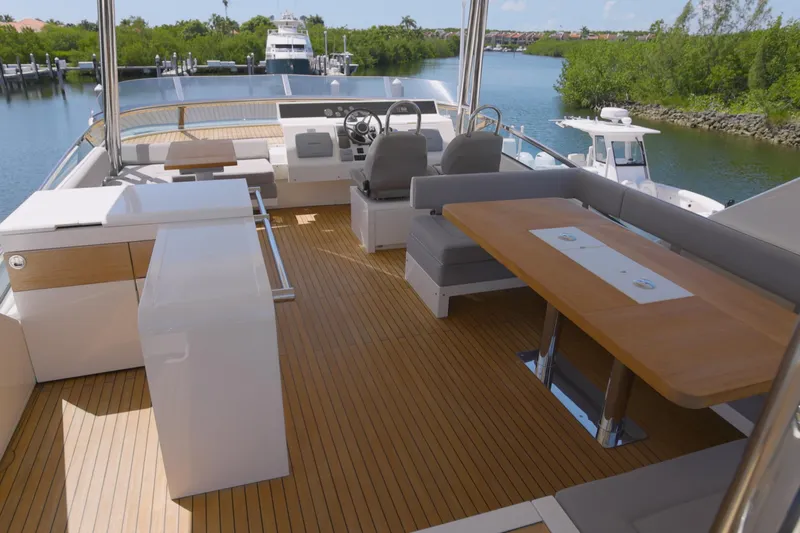  Yacht Photos Pics Luxurious 2014 Fairline Squadron 78 Custom yacht deck with seating and helm, docked by lush greenery.