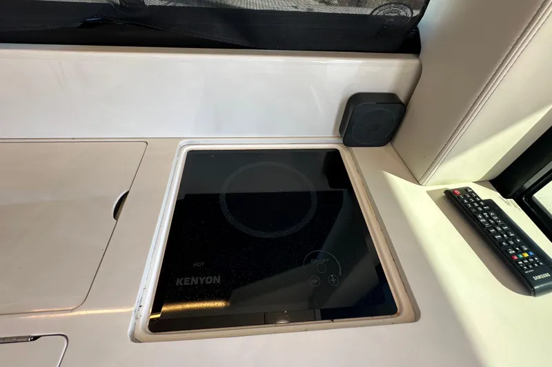  Yacht Photos Pics 2021 Regal 36 XO yacht interior with Kenyon cooktop and remote control.