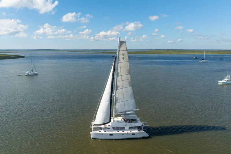 Worth The Wait Yacht Photos Pics Sailing Lagoon 560 catamaran from 2012 on calm waters under a clear blue sky.
