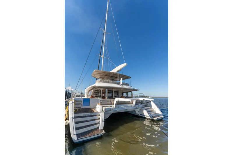 Worth The Wait Yacht Photos Pics Lagoon 560 catamaran, 2012 model, docked on calm waters under clear blue sky.