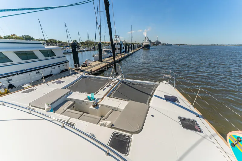Worth The Wait Yacht Photos Pics Lagoon 560 catamaran docked at marina, showcasing spacious deck and serene water view.
