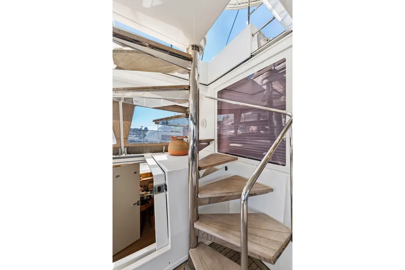 Worth The Wait Yacht Photos Pics Interior view of 2012 Lagoon 560 yacht with spiral staircase and modern design.