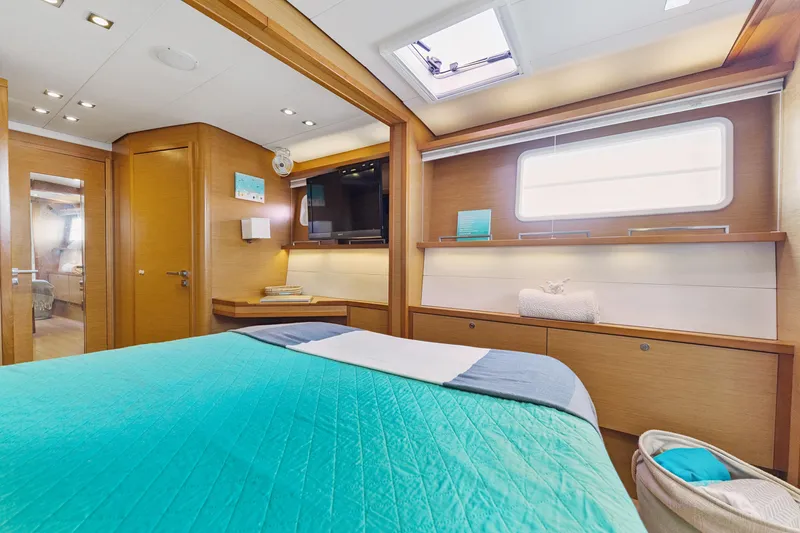 Worth The Wait Yacht Photos Pics Luxurious interior of 2012 Lagoon 560 yacht with modern wood finish and cozy bedding.