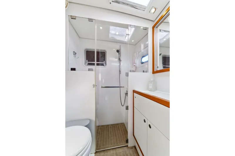 Worth The Wait Yacht Photos Pics Modern bathroom interior on 2012 Lagoon 560 yacht, featuring shower and sleek cabinetry.