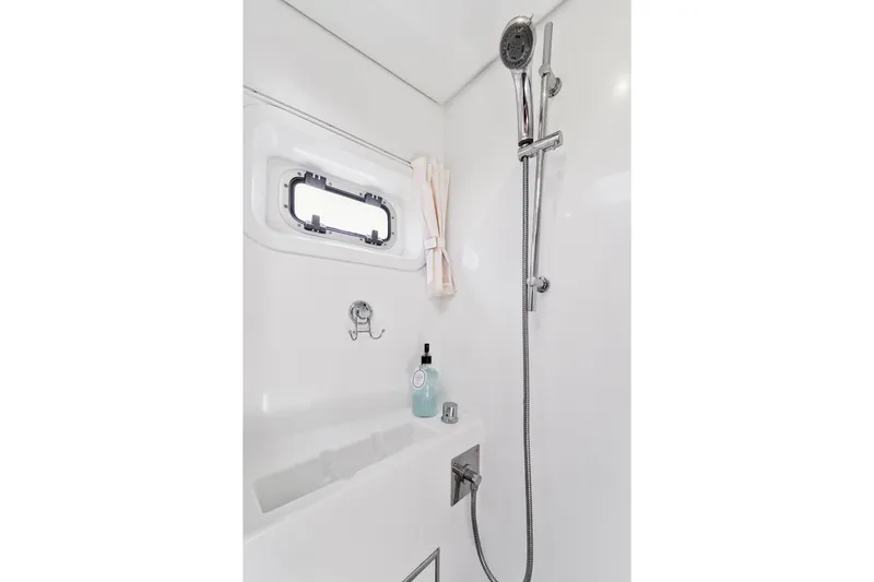 Worth The Wait Yacht Photos Pics Shower area in 2012 Lagoon 560 yacht with chrome fixtures and porthole window.