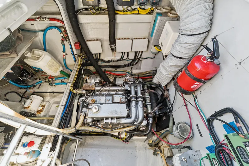 Worth The Wait Yacht Photos Pics Engine room of a 2012 Lagoon 560 yacht, featuring mechanical components and a fire extinguisher.