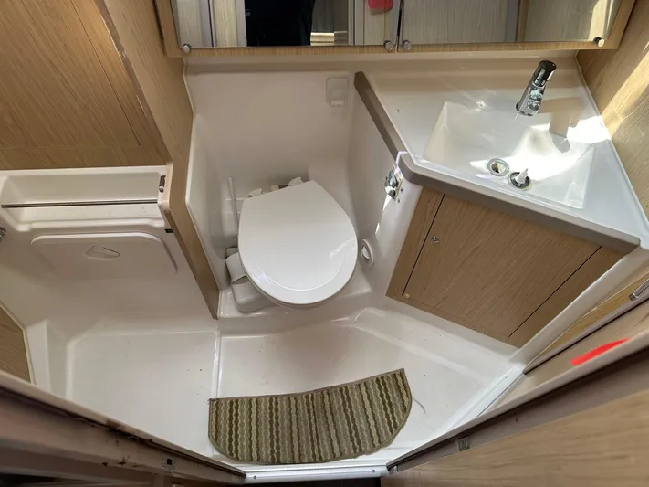  Yacht Photos Pics Beneteau Oceanis 41.1 2017 yacht bathroom with toilet, sink, and wooden cabinetry.