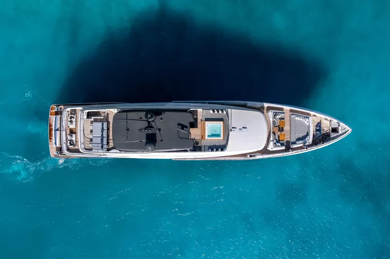Navetta Yacht Photos Pics Aerial view of 2023 Custom Line NAVETTA 42 yacht on clear blue water.