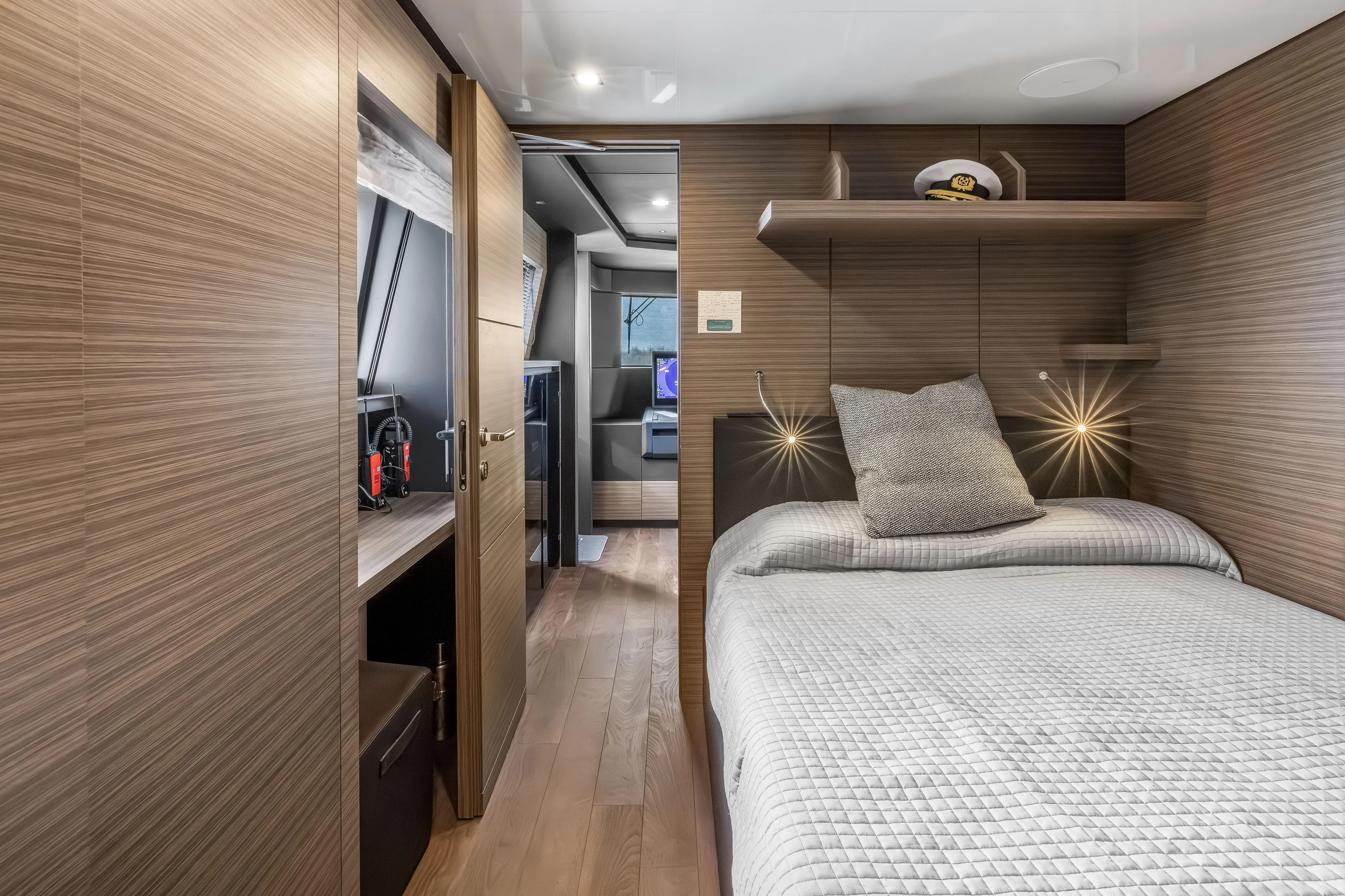 Navetta Yacht Photos Pics Luxurious 2023 Custom Line NAVETTA 42 yacht cabin with modern wood paneling and cozy bedding.