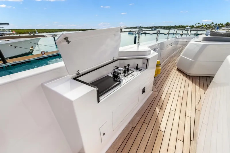 Navetta Yacht Photos Pics Luxurious 2023 Custom Line NAVETTA 42 yacht deck with sleek control panel and scenic marina view.