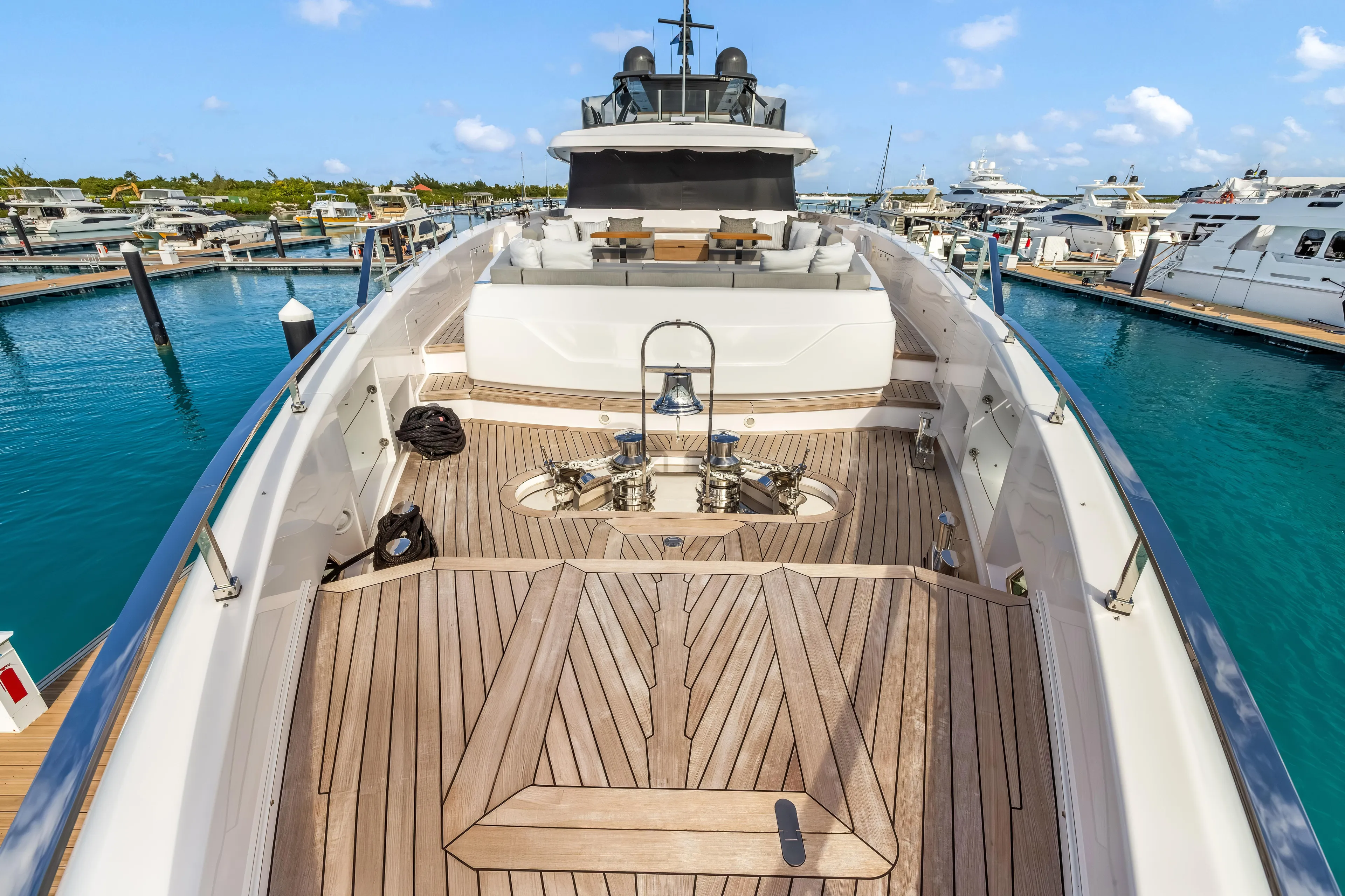 Navetta Yacht Photos Pics Luxurious 2023 Custom Line NAVETTA 42 yacht docked, featuring elegant teak decking and spacious seating area.