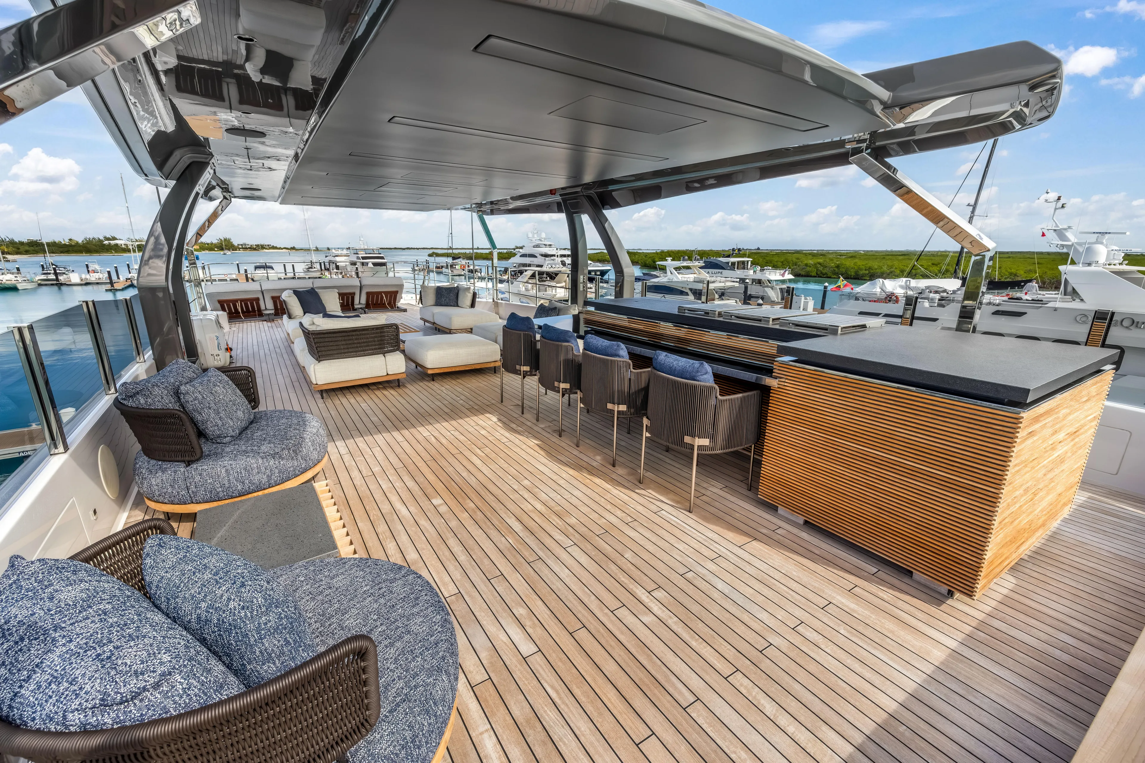 Navetta Yacht Photos Pics Luxurious 2023 Custom Line NAVETTA 42 yacht deck with elegant seating and bar area.