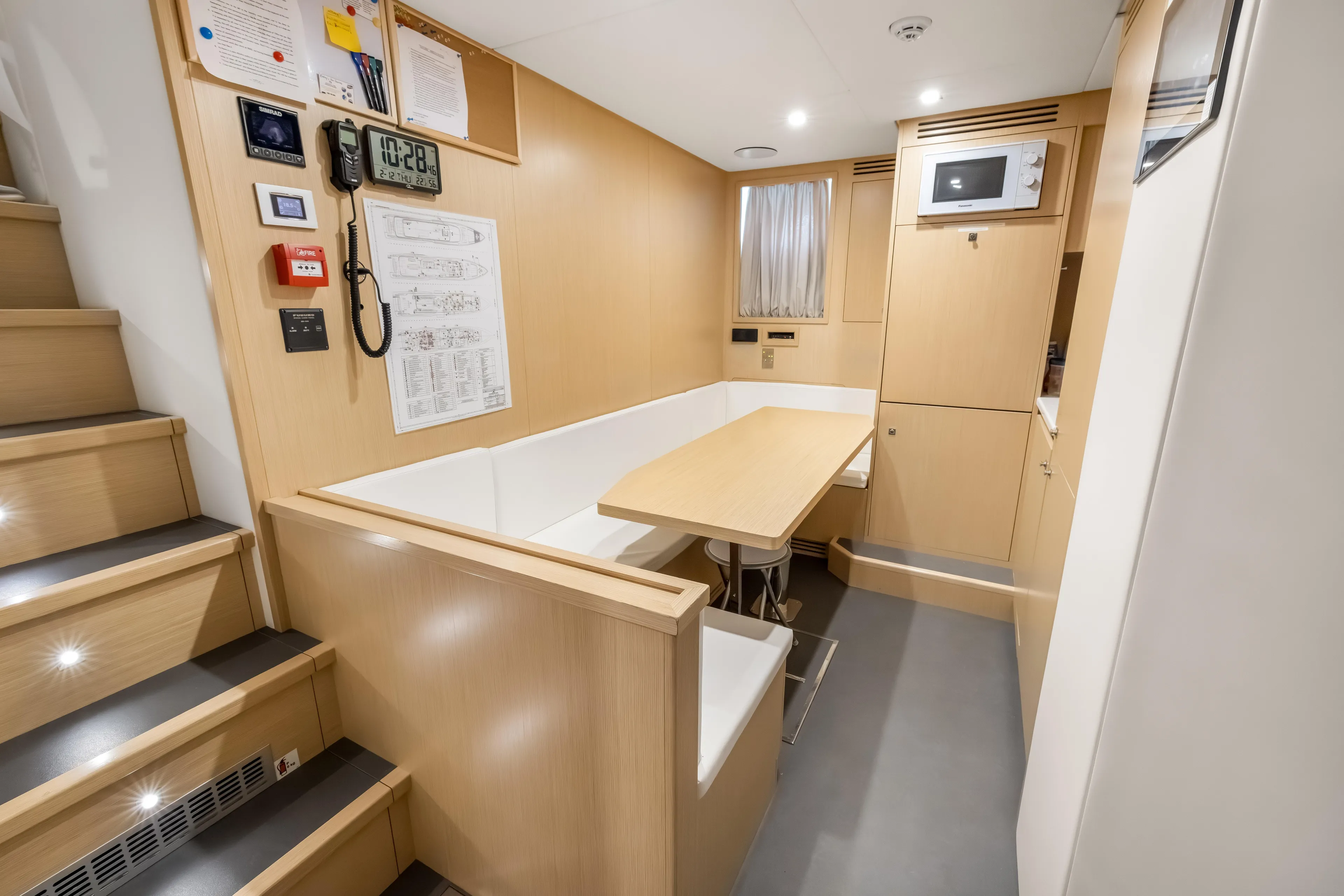 Navetta Yacht Photos Pics Modern interior of 2023 Custom Line NAVETTA 42 yacht with dining area and wooden finishes.