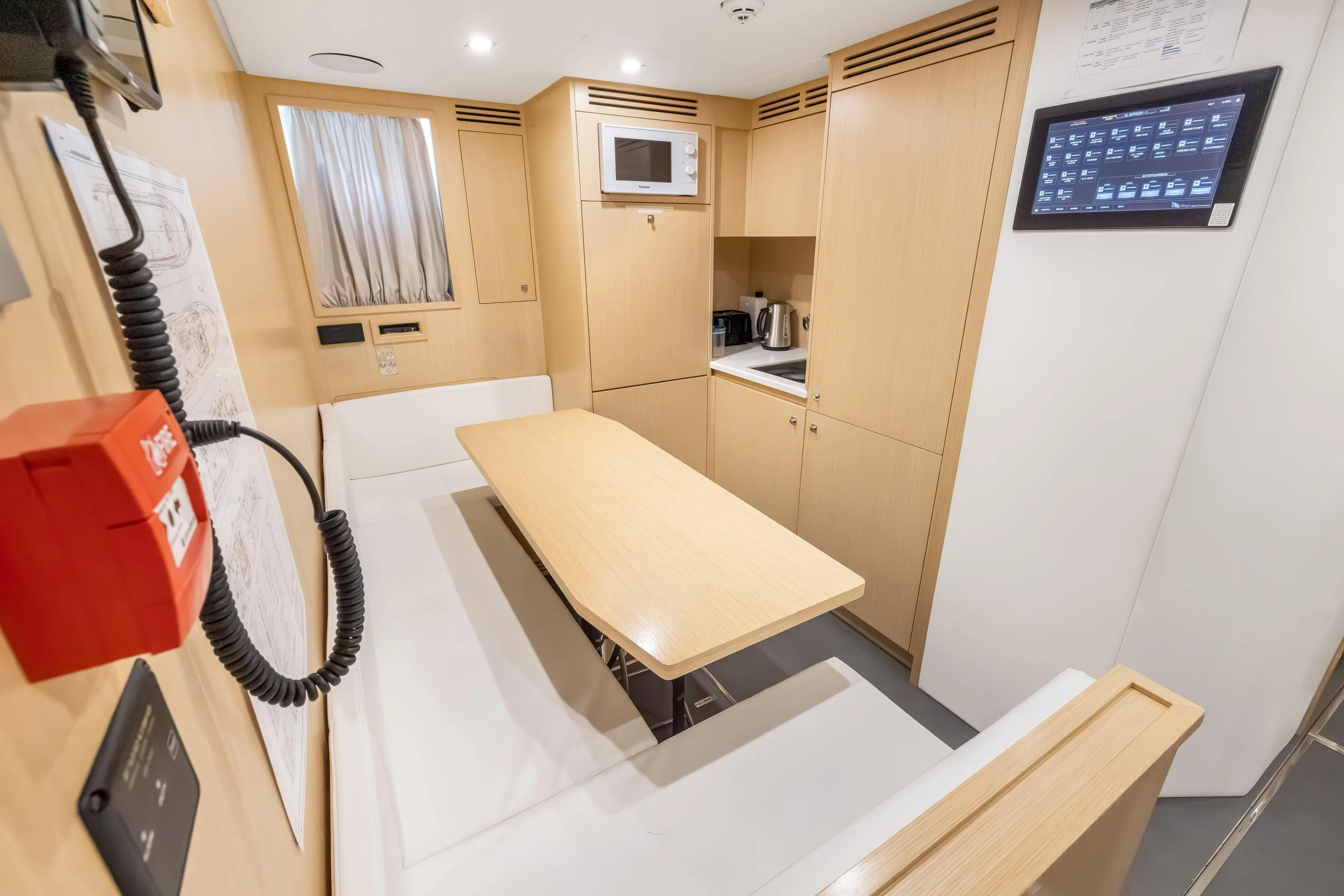 Navetta Yacht Photos Pics Modern interior of 2023 Custom Line NAVETTA 42 yacht with kitchenette and seating area.