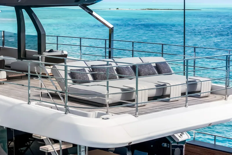Navetta Yacht Photos Pics Luxurious 2023 Custom Line NAVETTA 42 yacht deck with plush seating, overlooking turquoise ocean waters.