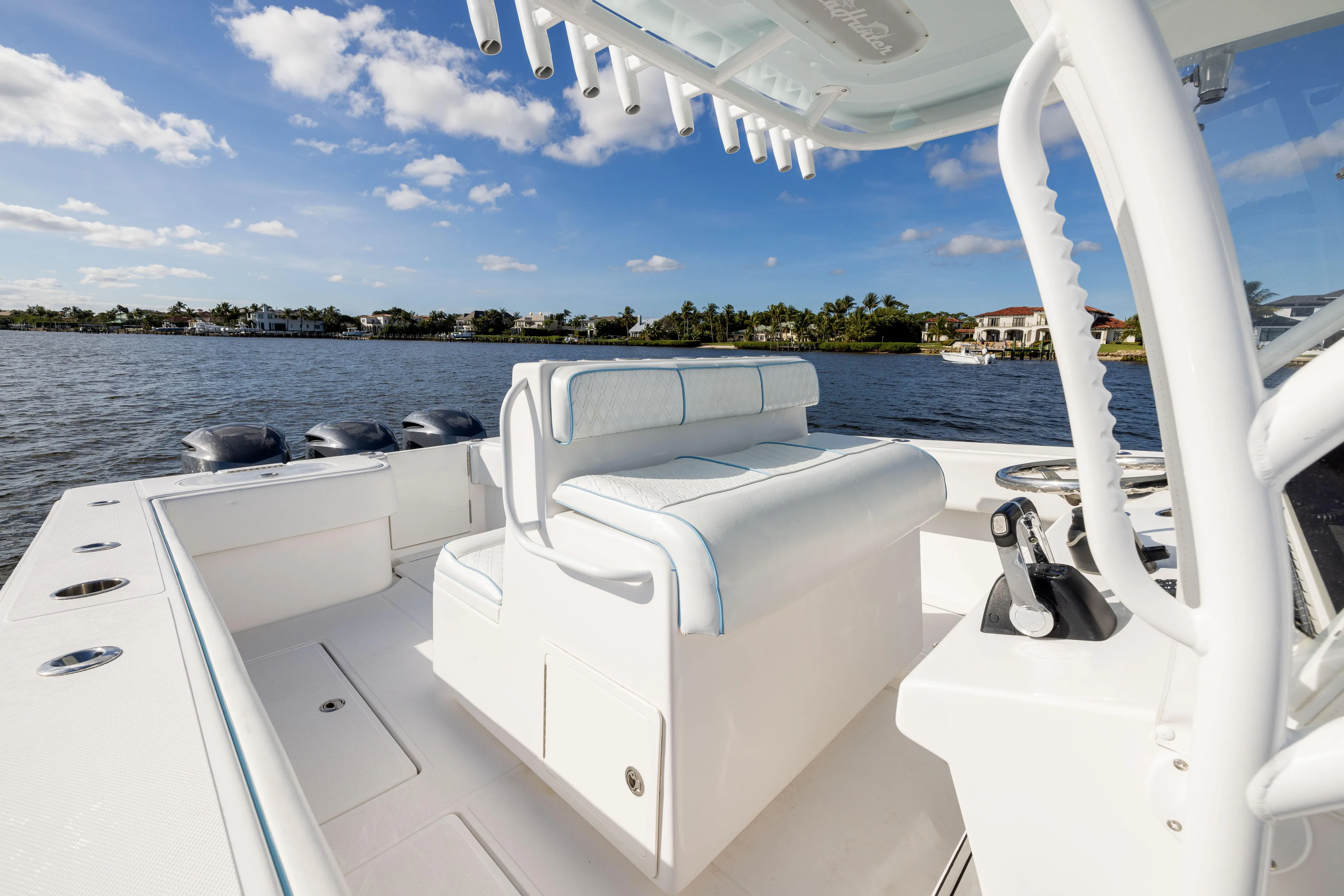 Bloodline Yacht Photos Pics 2018 SeaHunter 33' Center Console boat on calm water, featuring sleek white seating and controls.