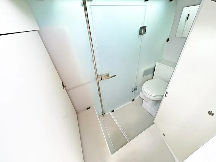  Yacht Photos Pics 2024 Axopar 37 Sun Top bathroom with modern design and frosted glass door.