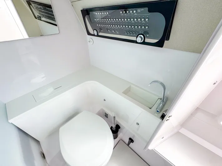 Yacht Photos Pics 2024 Axopar 37 Sun Top bathroom with modern fixtures and control panel.