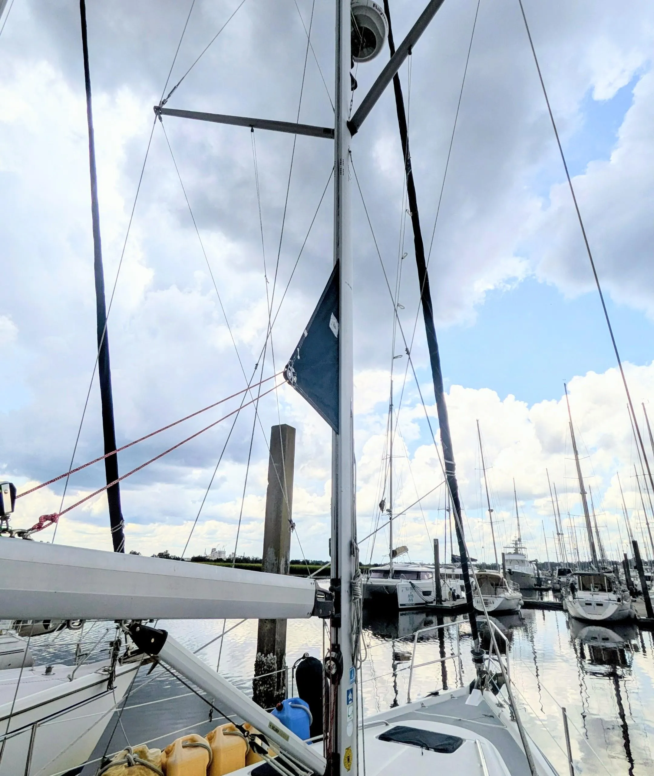 Sailboat Hunter 380, 2001 model, docked at marina under cloudy sky.