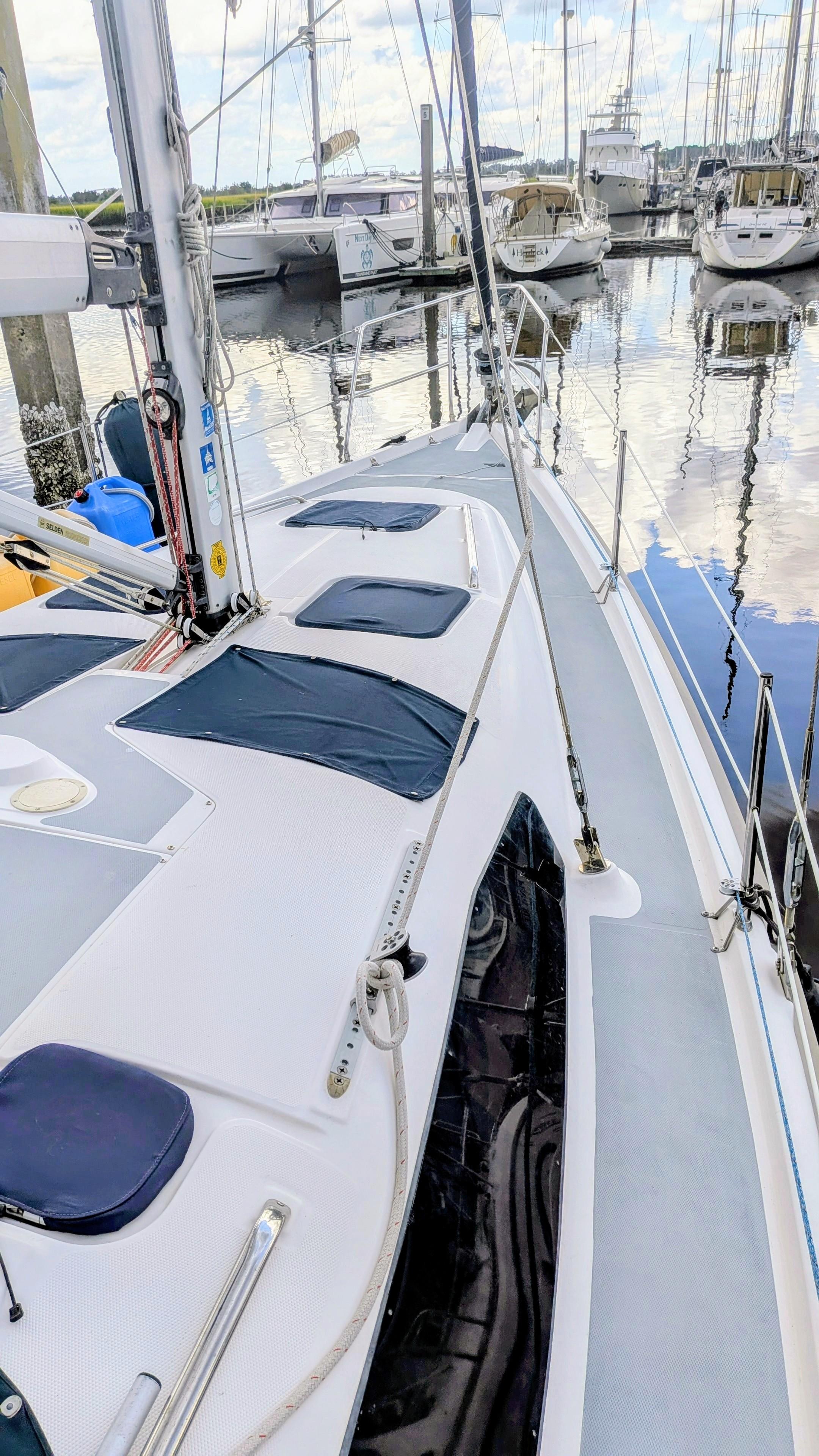 Sailboat Hunter 380, 2001 model, docked in marina with other boats in background.