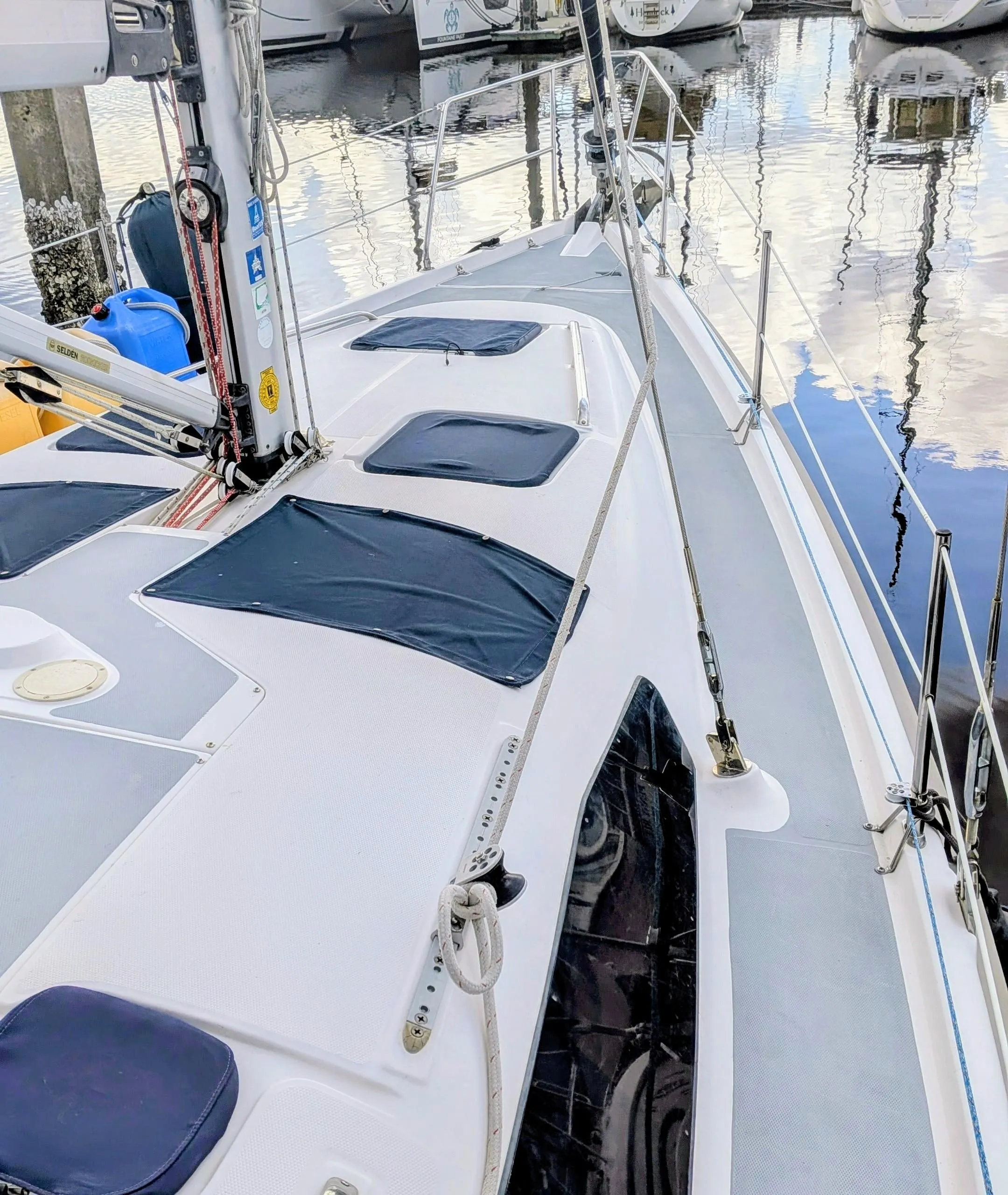Sailboat Hunter 380, 2001 model, docked in marina with other boats in background.