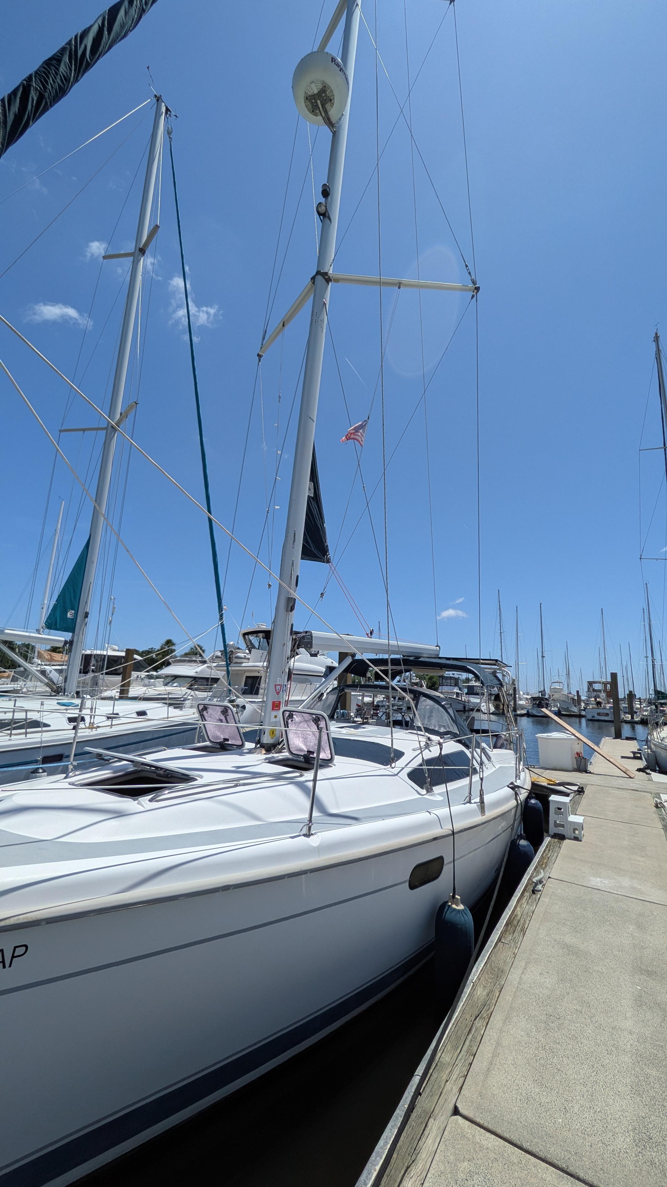Sailboat docked at marina, Hunter 380 model, 2001, under clear blue sky.