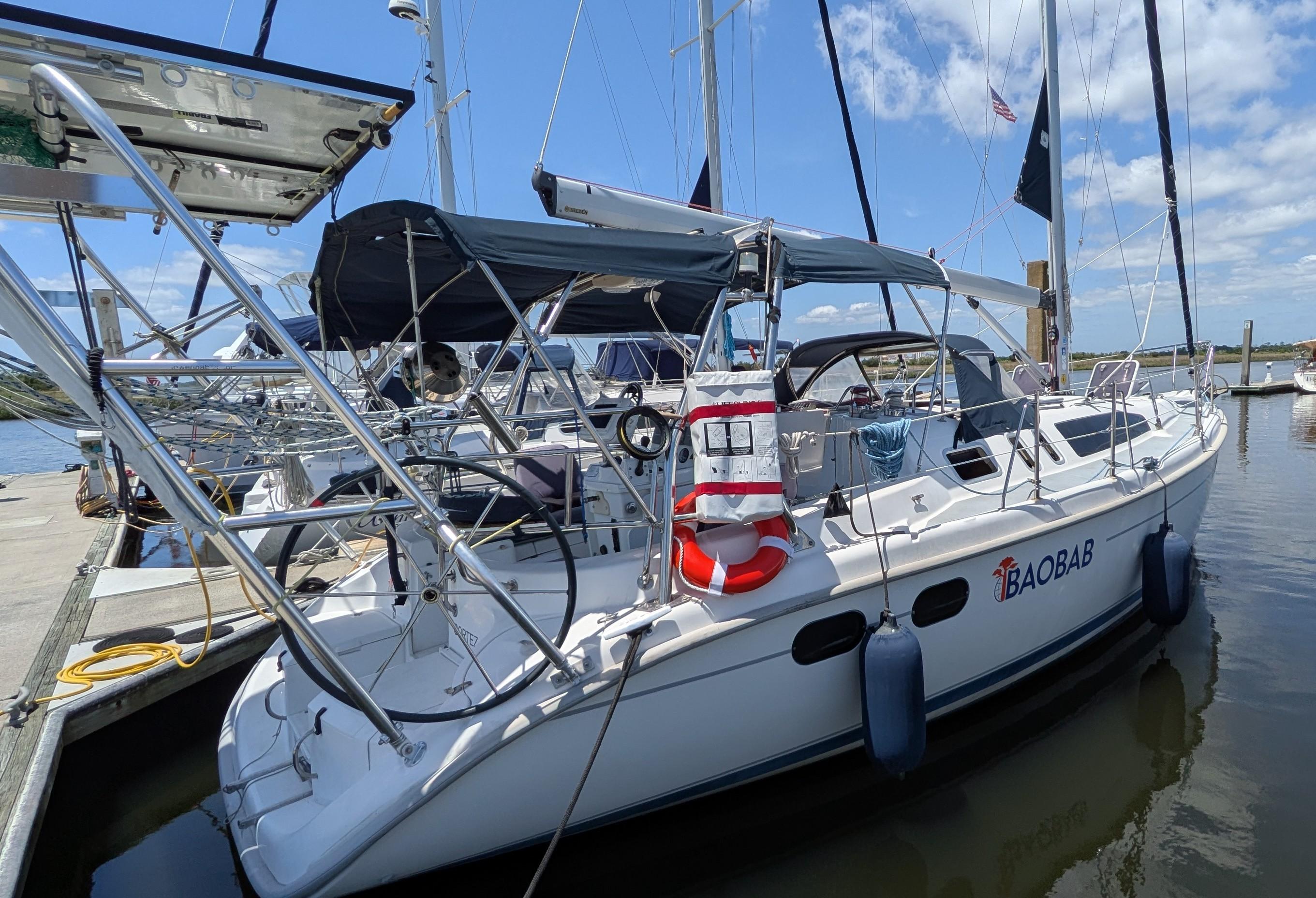 Sailboat Hunter 380, 2001 model, docked at marina under clear blue sky.