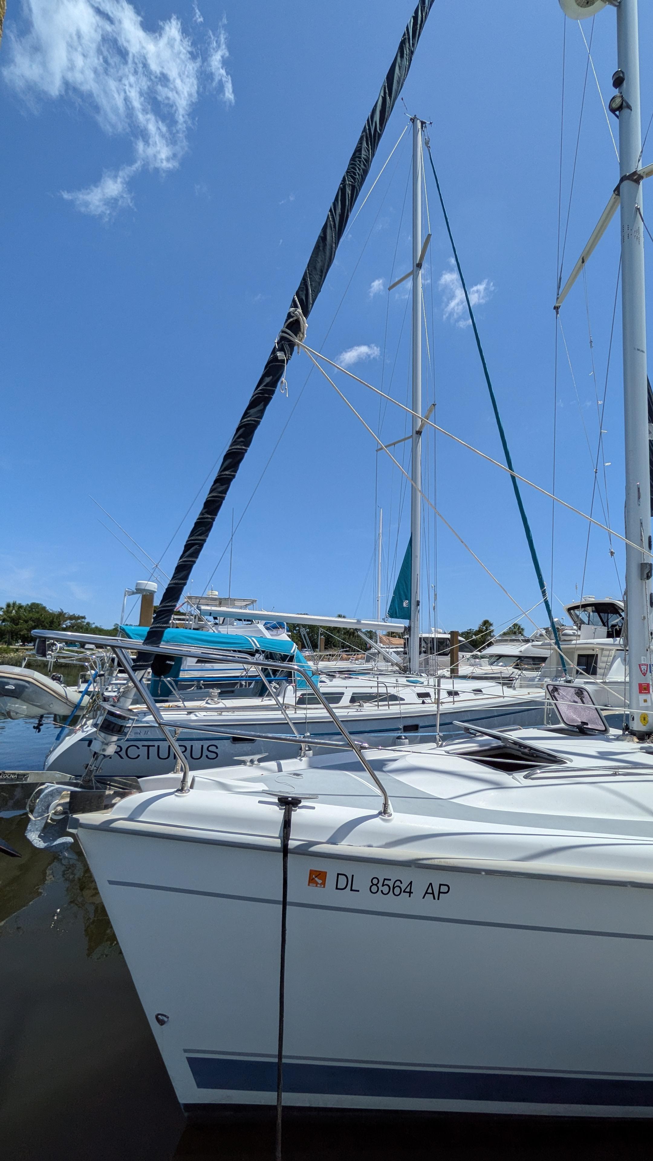 Sailboat Hunter 380, 2001 model, docked in a marina under clear blue skies.