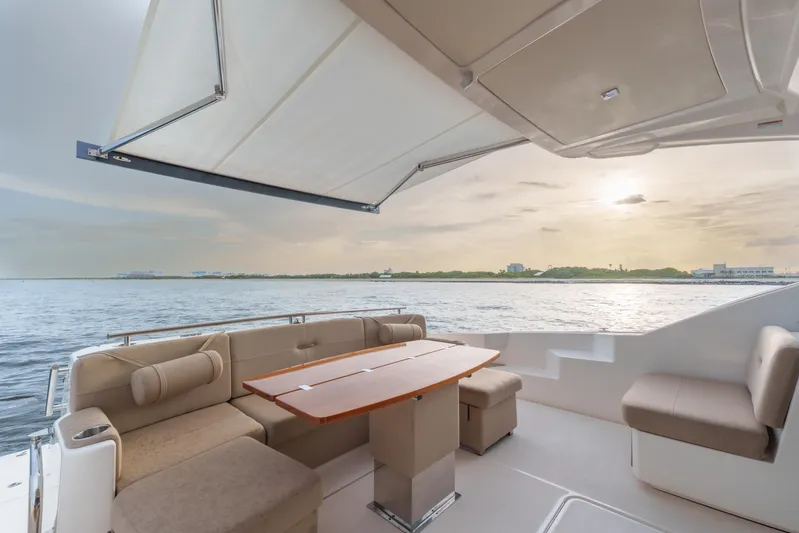 Happy Daze IV Yacht Photos Pics Luxurious 2017 Tiara Yachts C53 Coupe deck with seating, overlooking serene ocean sunset.