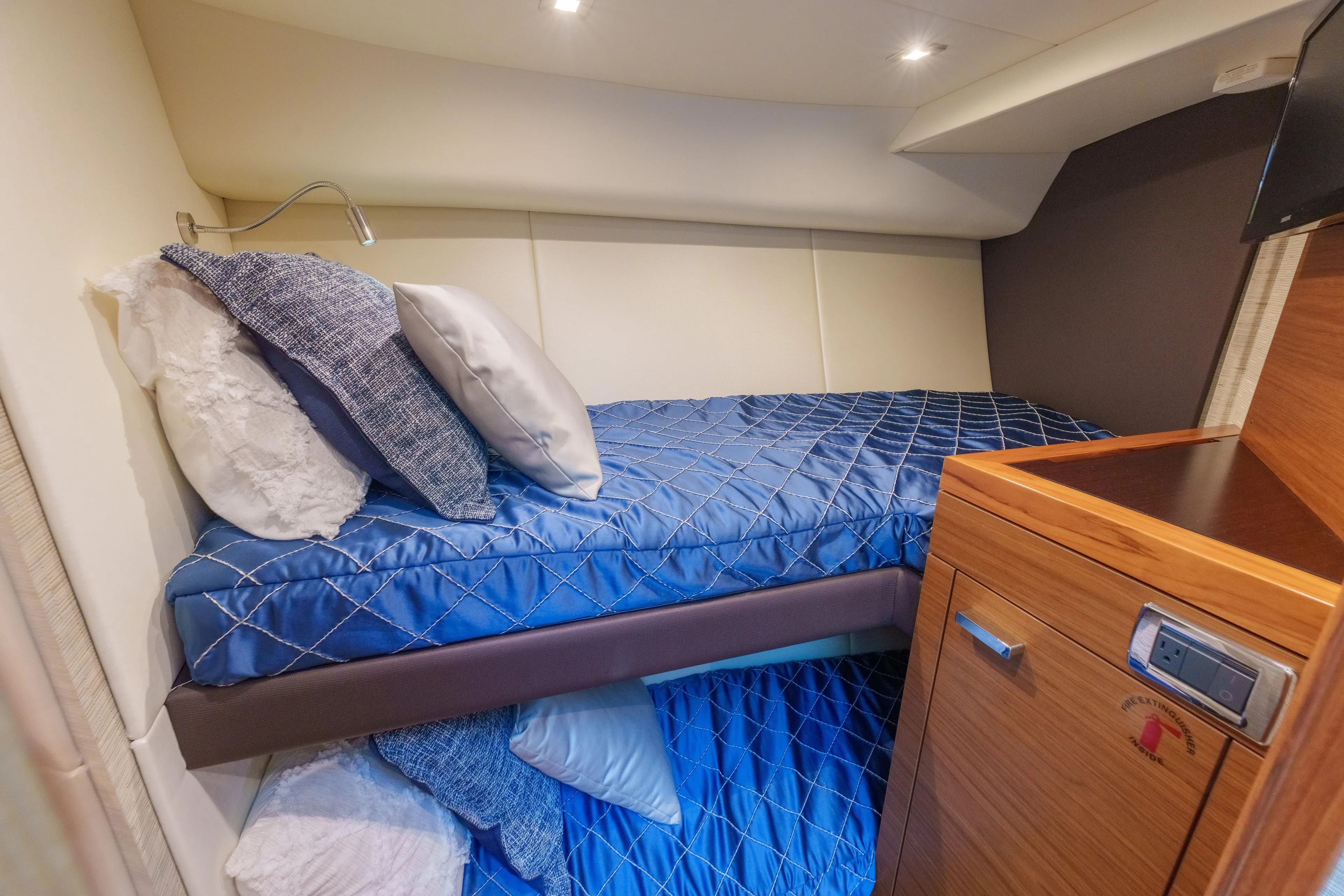 Happy Daze IV Yacht Photos Pics 2017 Tiara Yachts C53 Coupe cabin with blue bedding and wooden cabinetry.