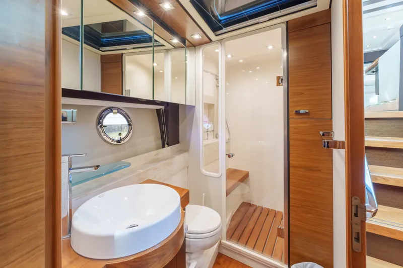 Happy Daze IV Yacht Photos Pics Luxurious bathroom in 2017 Tiara Yachts C53 Coupe with modern fixtures and wooden accents.