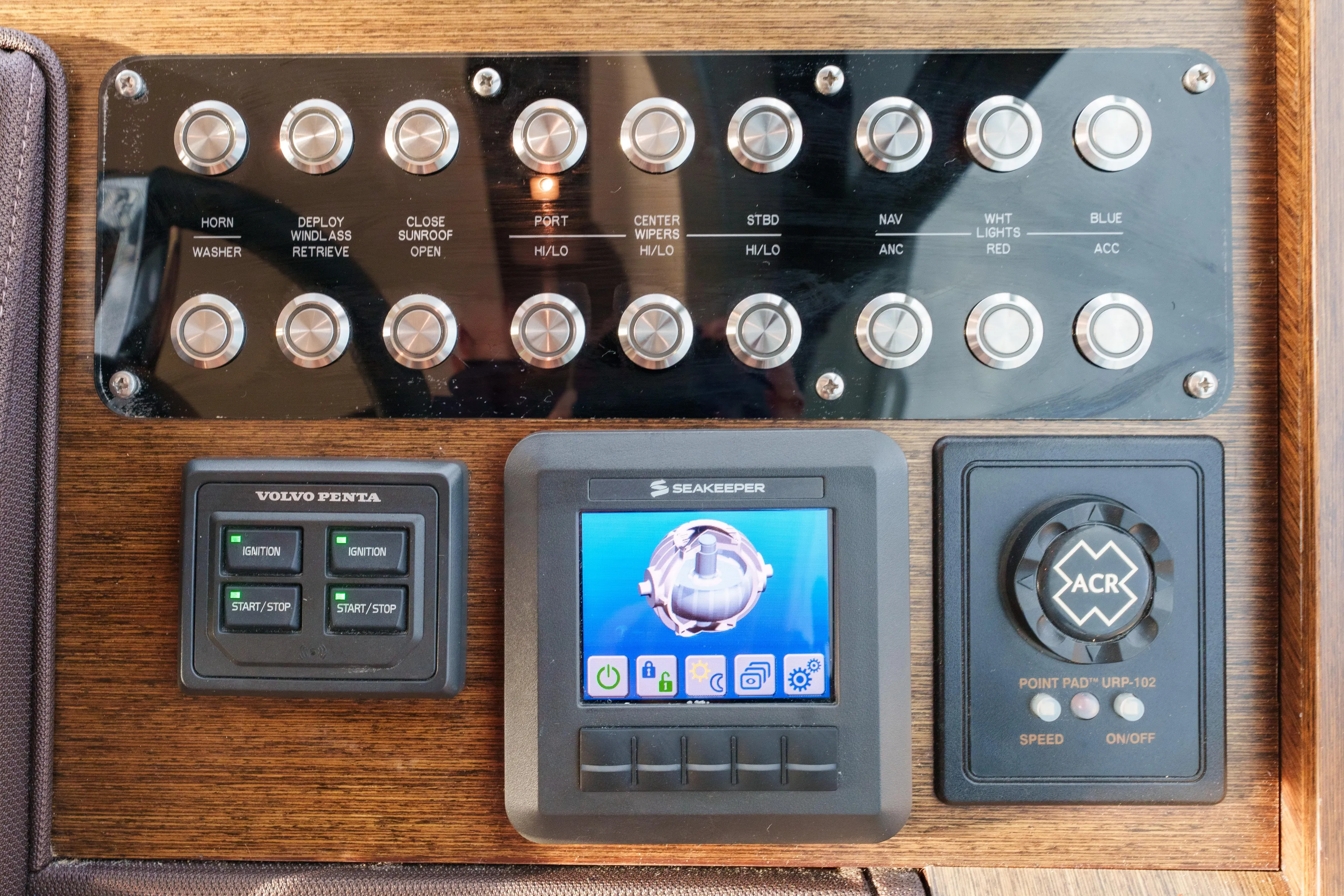 Happy Daze IV Yacht Photos Pics Control panel of a 2017 Tiara Yachts C53 Coupe with various switches and displays.